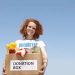 volunteer carrying food donation box