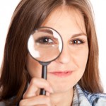 Girl is looking through magnifying glass investigating grocery store myths facts paper versus plastic bags