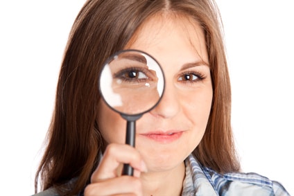 Girl is looking through magnifying glass investigating grocery store myths facts paper versus plastic bags