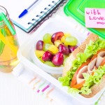 Bento lunch for your child in school, box with a healthy sandwich and fruit salad and apple juice in the bottle for drinking