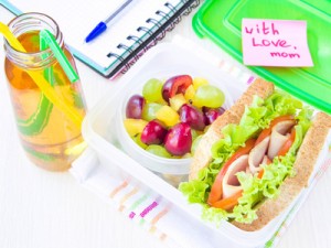 Bento lunch for your child in school, box with a healthy sandwich and fruit salad and apple juice in the bottle for drinking