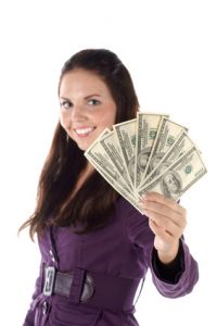 Smiling female with pile of dollar (focus on hand)