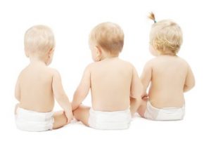 Baby in diapers sitting back side, white background